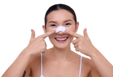 Photo of Woman with medical bandage on her nose after plastic surgery operation against white background