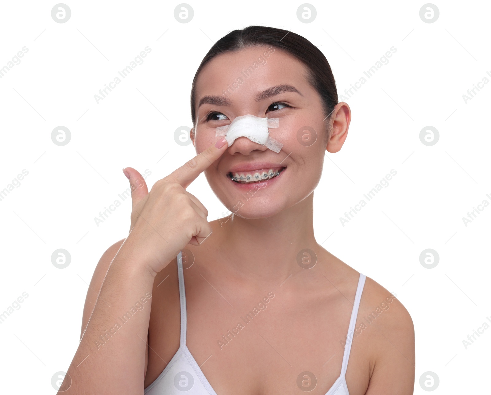 Photo of Woman with medical bandage on her nose after plastic surgery operation against white background