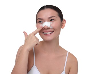 Photo of Woman with medical bandage on her nose after plastic surgery operation against white background