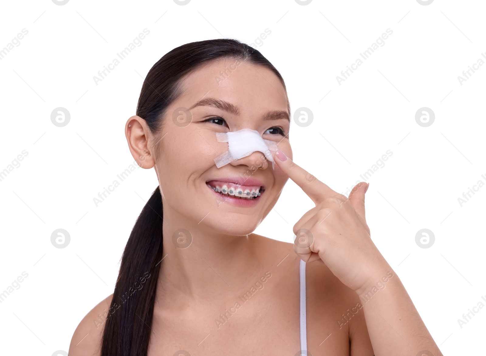 Photo of Woman with medical bandage on her nose after plastic surgery operation against white background