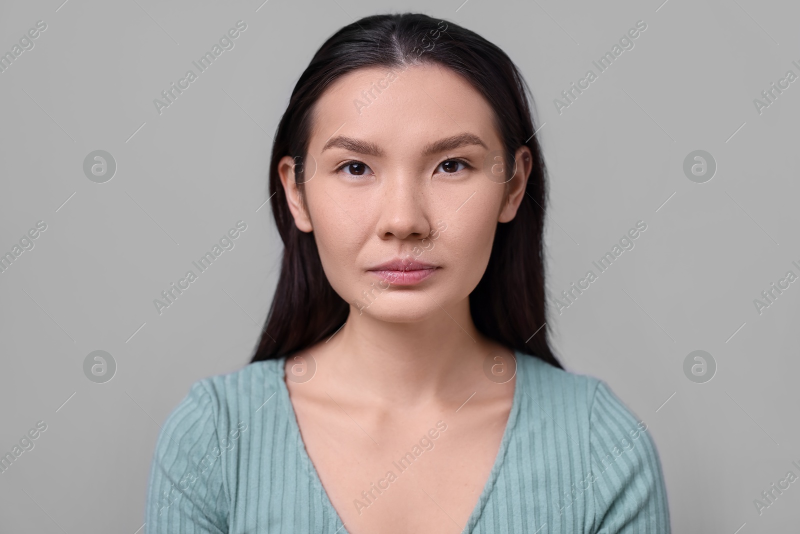 Photo of Woman with beautiful nose on light grey background. Rhinoplasty surgery