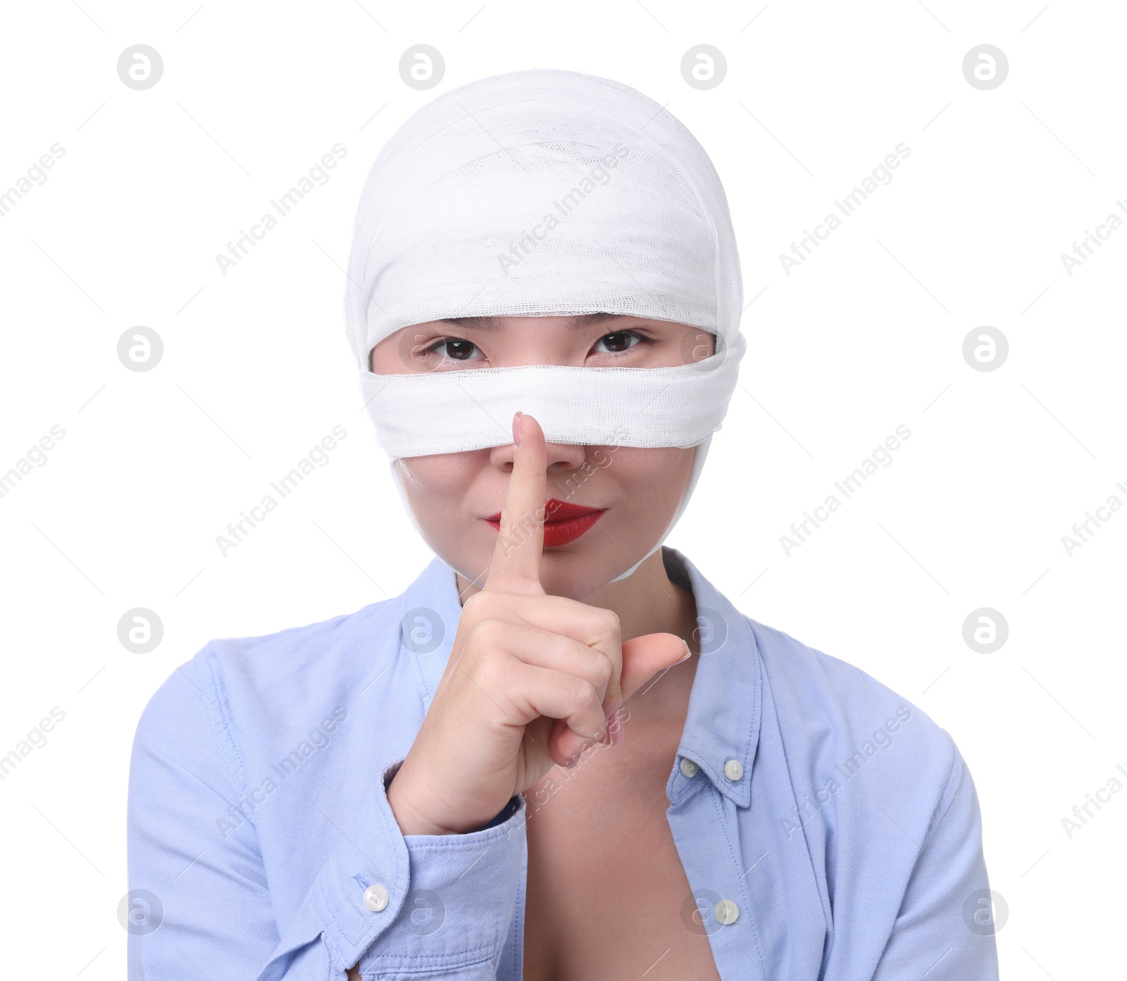 Photo of Woman with nose wrapped in medical bandage after plastic surgery operation making silent gesture on white background