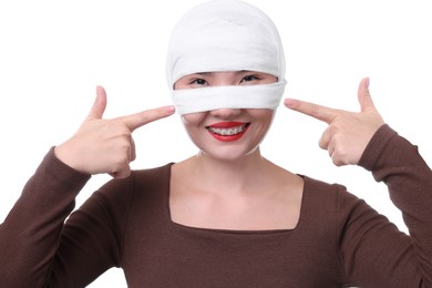 Photo of Woman with nose wrapped in medical bandage after plastic surgery operation on white background