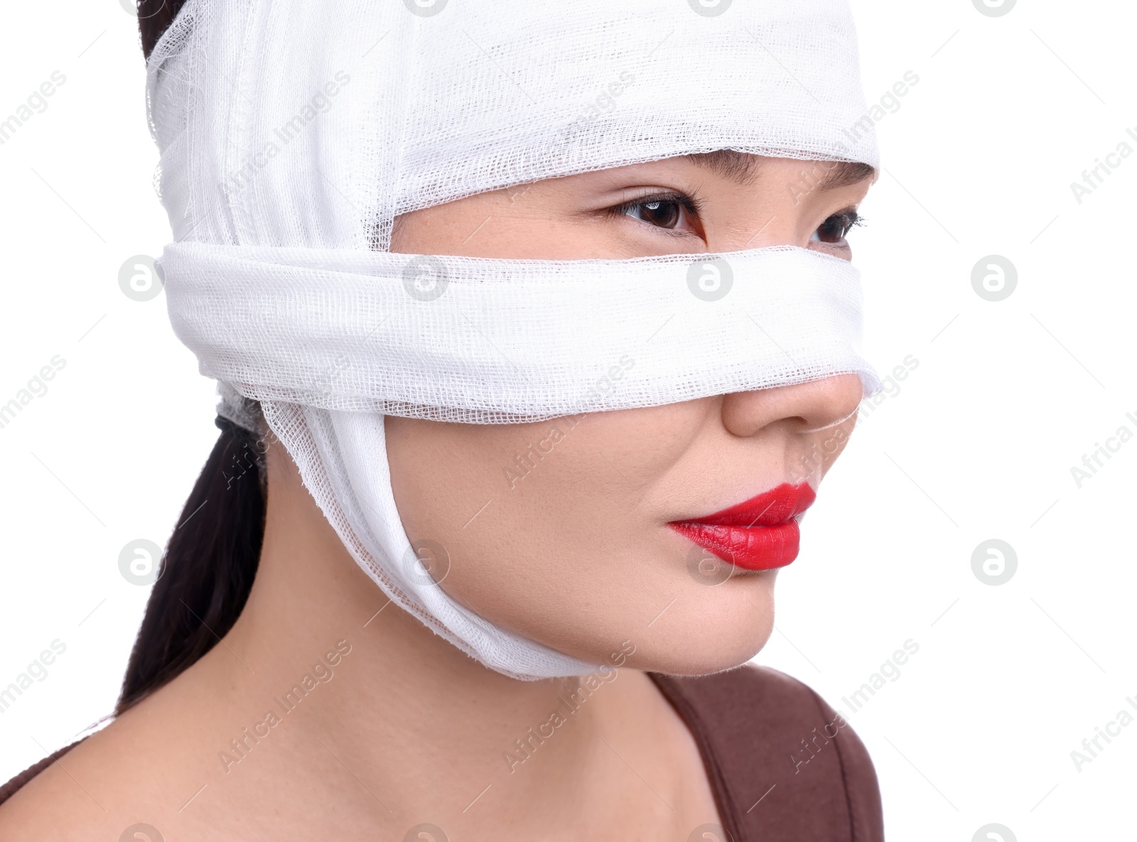 Photo of Woman with nose wrapped in medical bandage after plastic surgery operation on white background, closeup