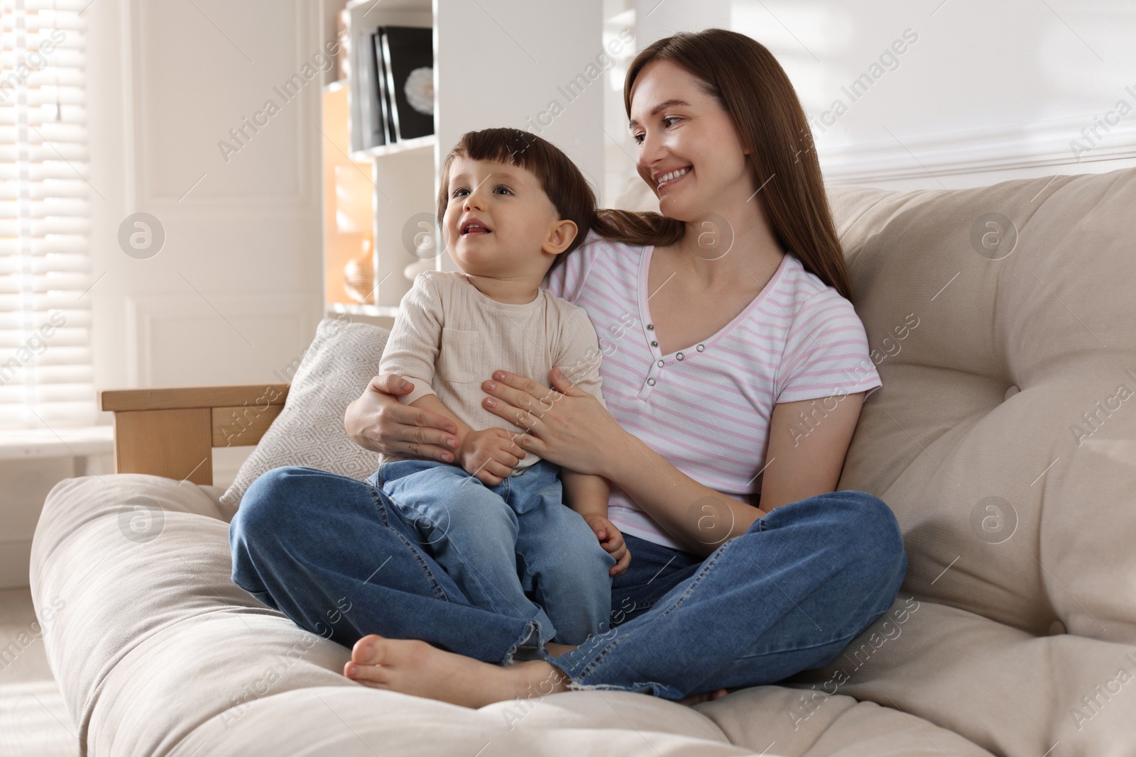 Photo of Happy mother with her cute little son on sofa at home