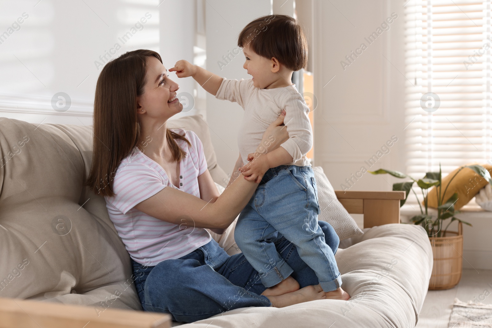 Photo of Happy mother with her cute little son on sofa at home