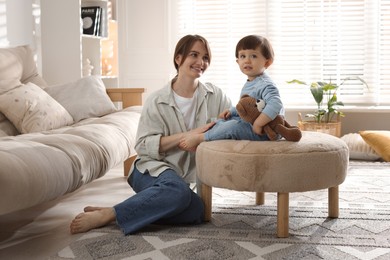 Photo of Happy mother and her cute little son with toy bear at home