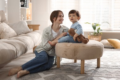 Photo of Happy mother and her cute little son with toy bear at home