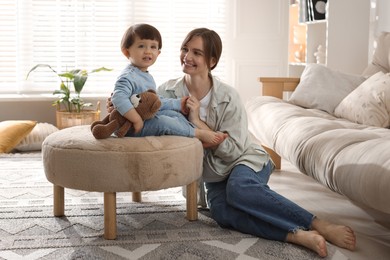 Photo of Happy mother and her cute little son with toy bear at home