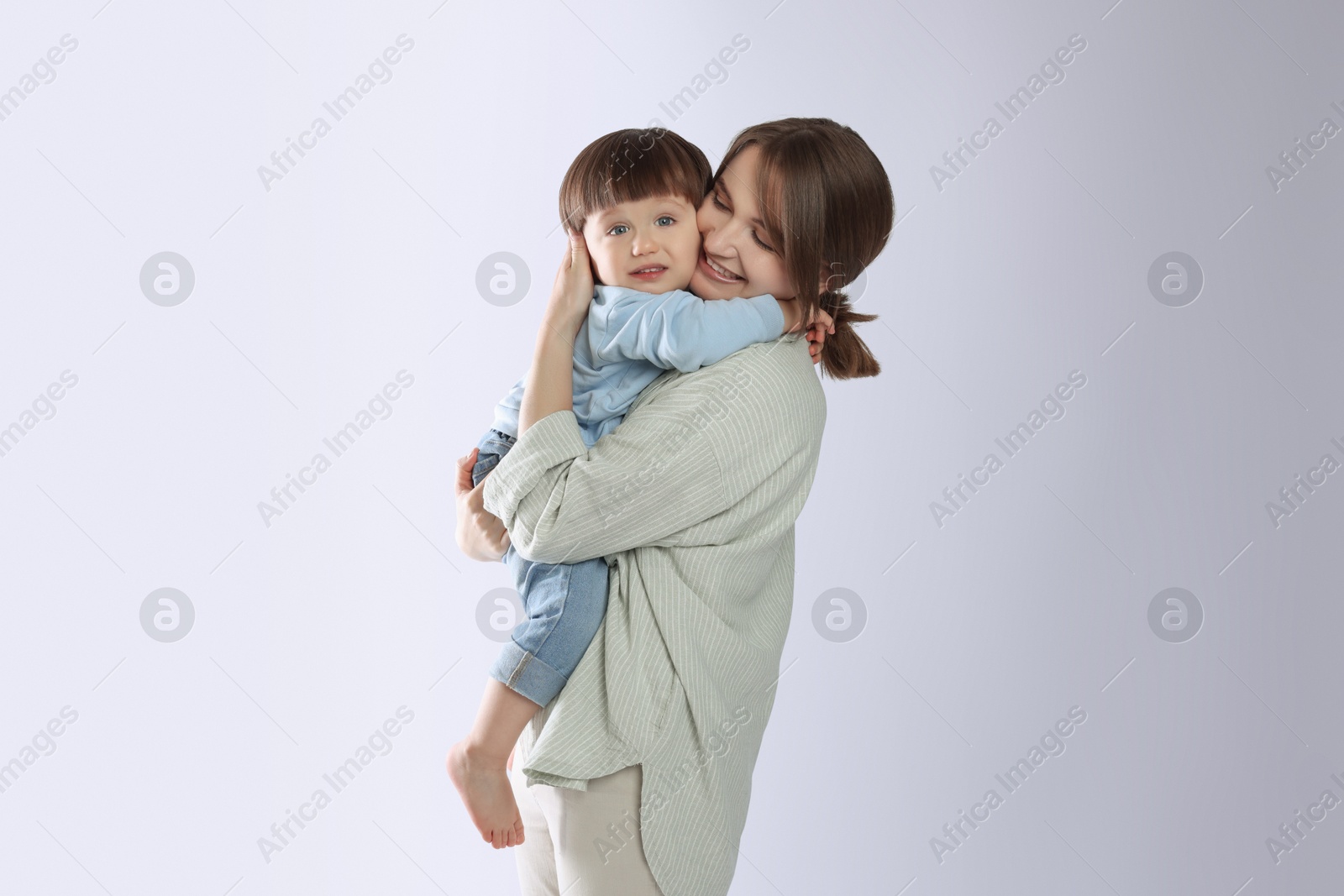 Photo of Beautiful mother with her cute little son on light grey background