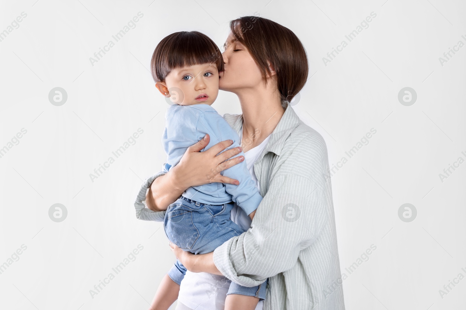 Photo of Beautiful mother with her cute little son on light grey background