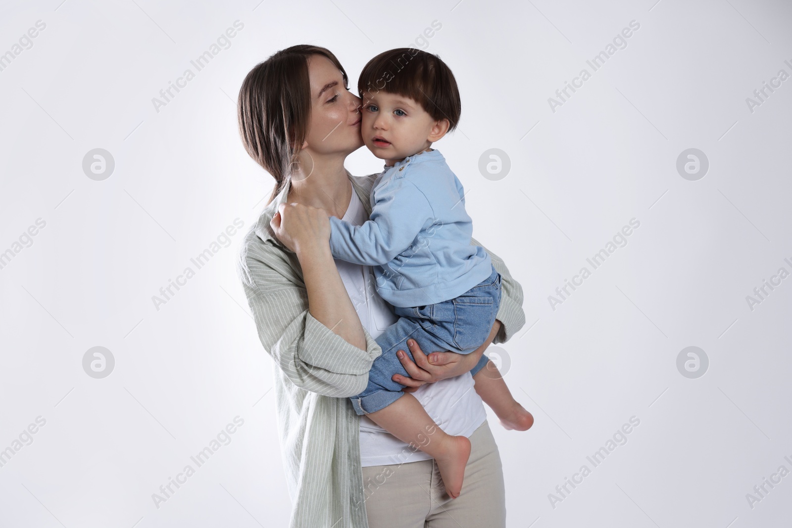 Photo of Beautiful mother with her cute little son on light grey background