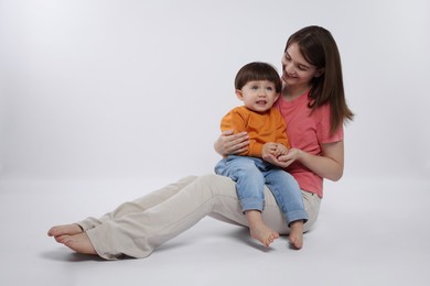 Photo of Happy mother with her cute little son on white background