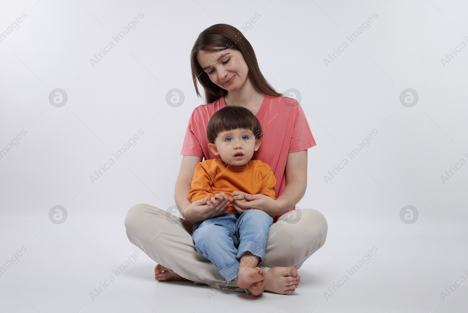 Photo of Beautiful mother with her cute little son on white background