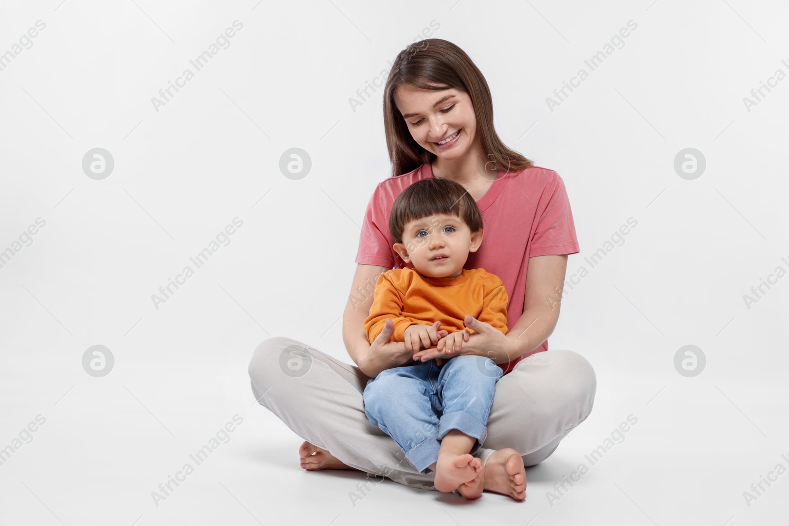 Photo of Happy mother with her cute little son on white background. Space for text