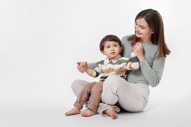 Photo of Happy mother with her cute little son on white background, space for text