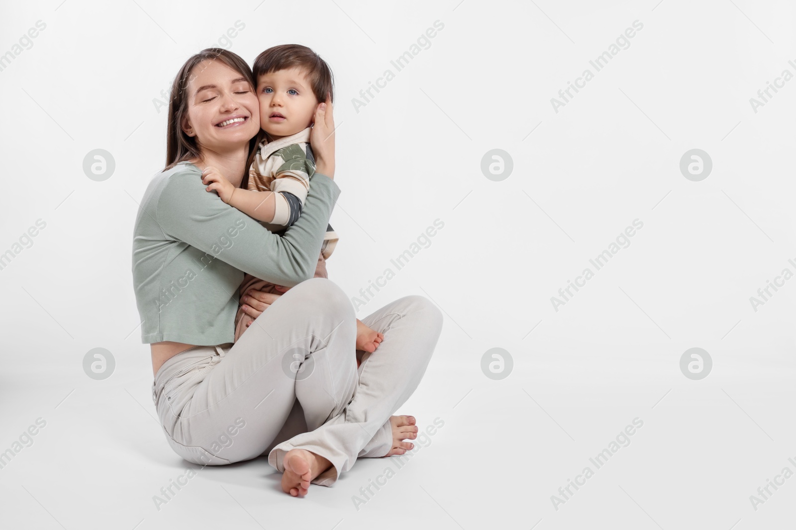 Photo of Happy mother with her cute little son on white background, space for text