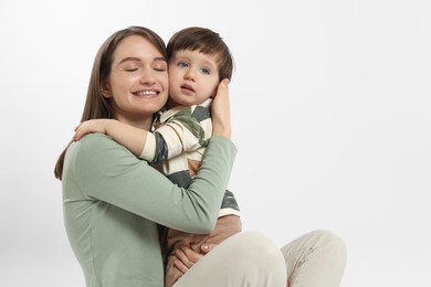 Photo of Happy mother with her cute little son on white background, space for text