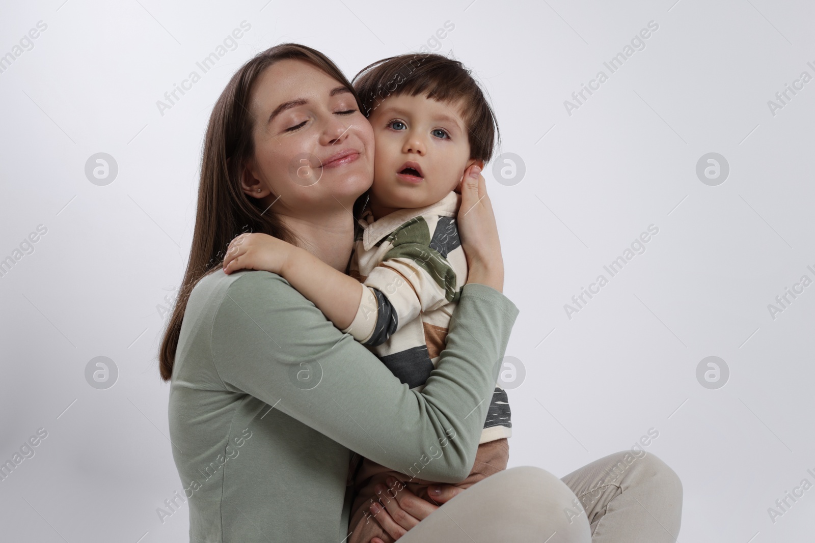 Photo of Beautiful mother with her cute little son on white background, space for text