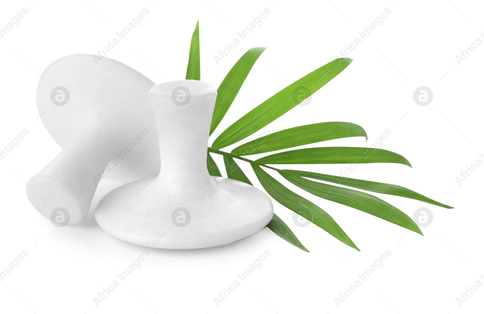 Photo of Spa stones and green palm leaf isolated on white