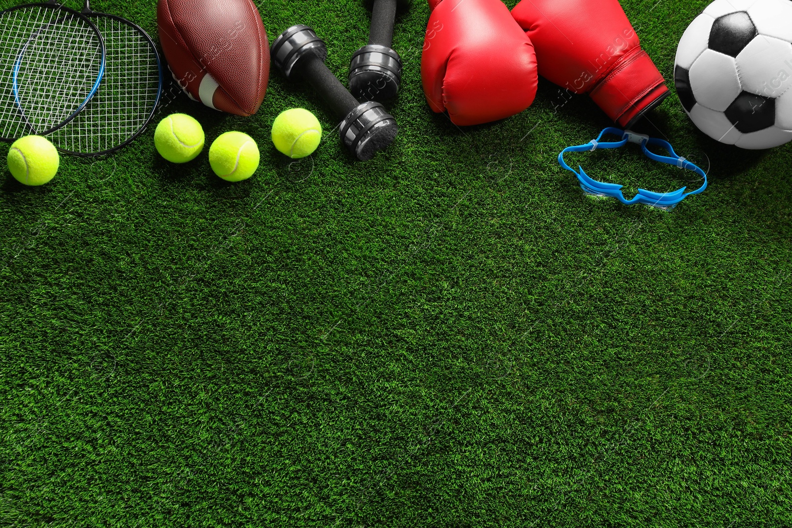 Photo of Different sports equipment on artificial grass, flat lay. Space for text