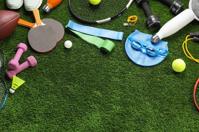 Different sports equipment on artificial grass, flat lay. Space for text