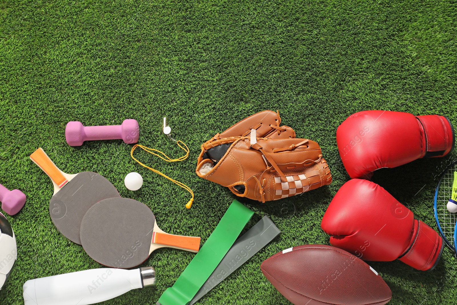 Photo of Different sports equipment on artificial grass, flat lay. Space for text