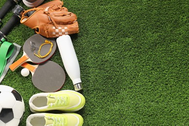 Photo of Different sports equipment on artificial grass, flat lay. Space for text