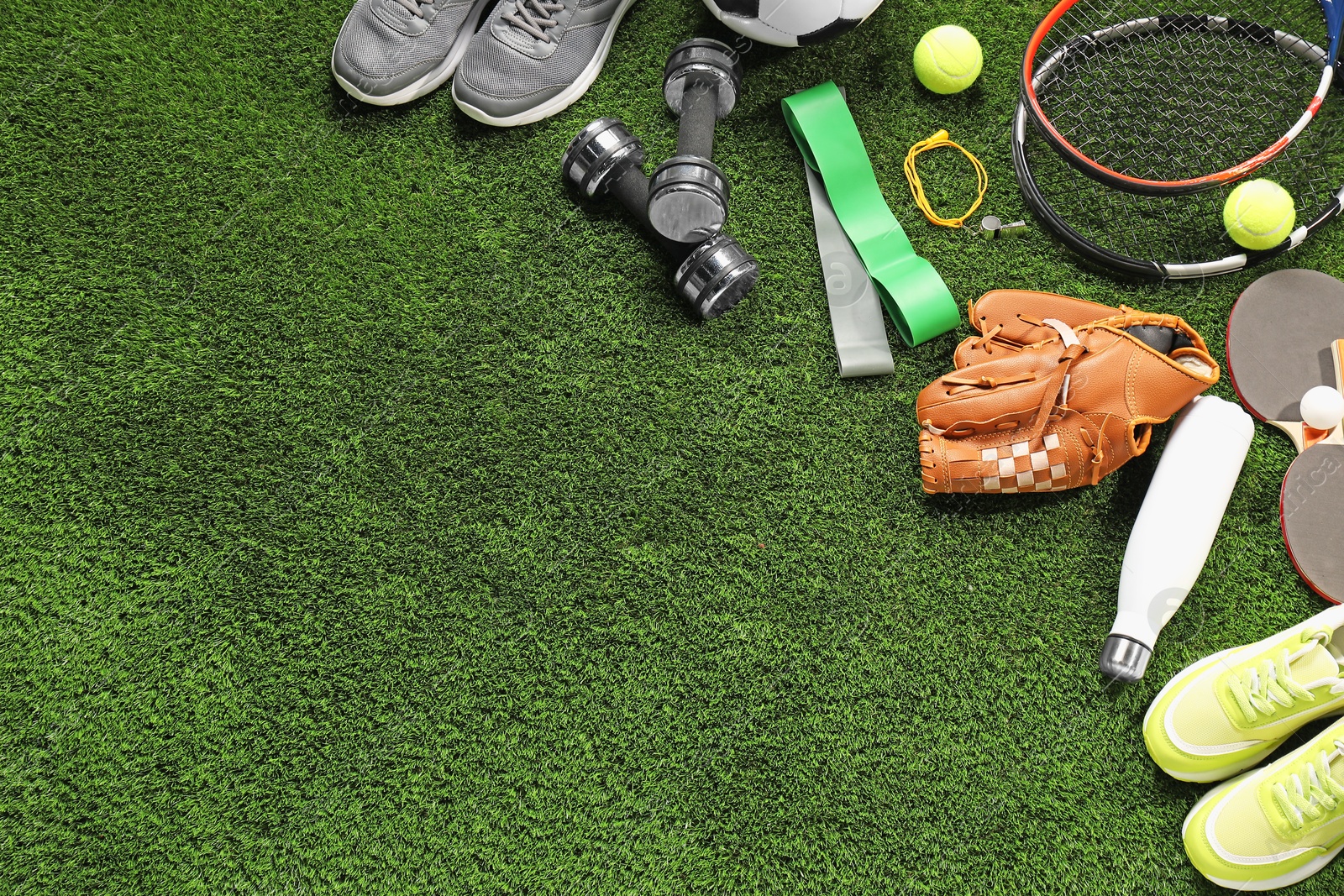 Photo of Different sports equipment on artificial grass, flat lay. Space for text