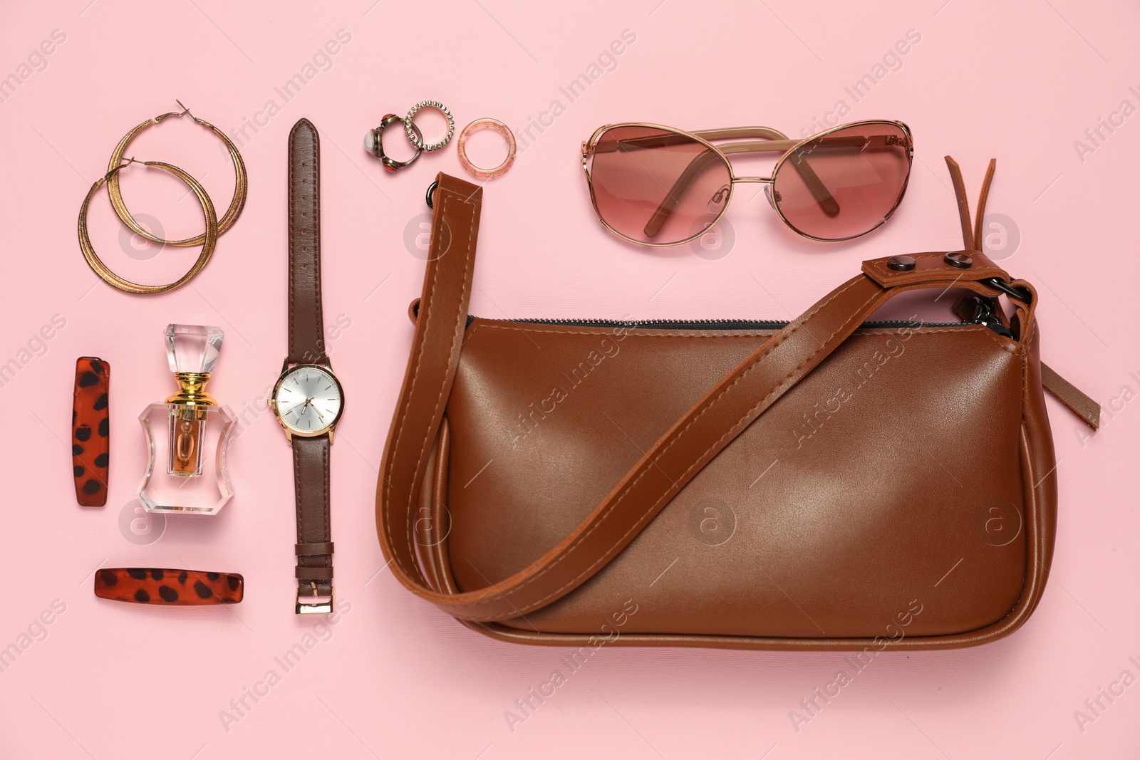 Photo of Many stylish jewelry, perfume and accessories on pink background, flat lay