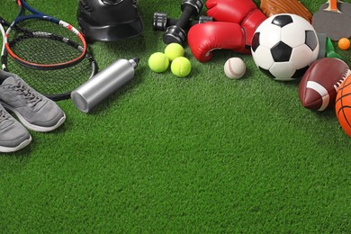 Photo of Different sport equipment on artificial grass, above view. Space for text