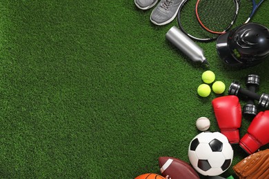 Photo of Different sport equipment on artificial grass, flat lay. Space for text