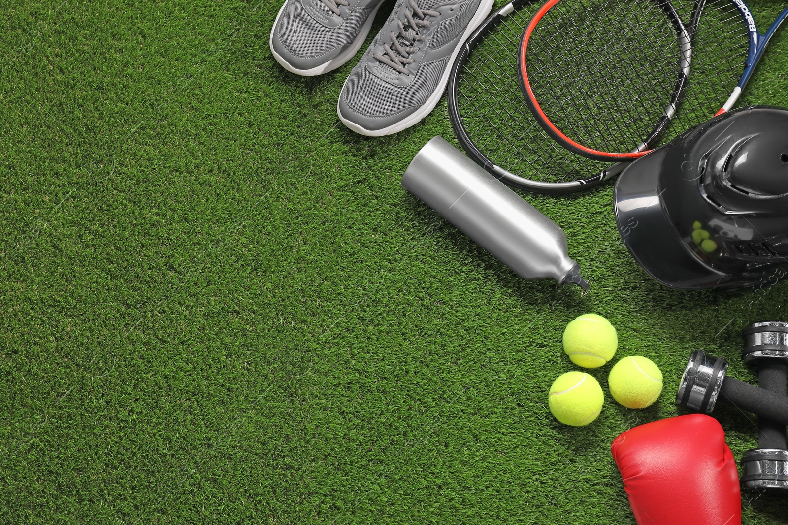 Photo of Different sport equipment on artificial grass, flat lay. Space for text