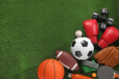 Photo of Different sport equipment on artificial grass, flat lay. Space for text