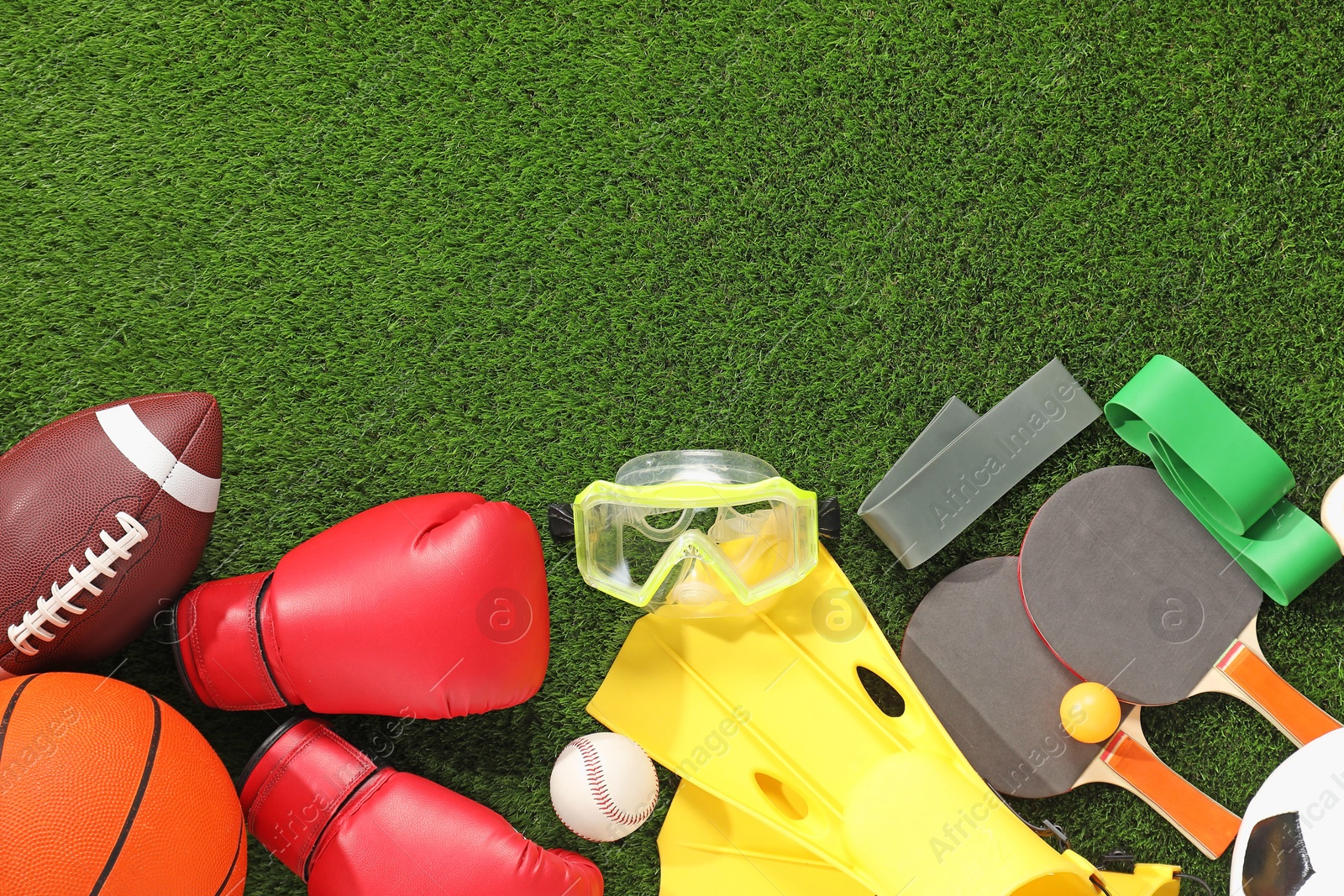 Photo of Different sport equipment on artificial grass, flat lay. Space for text