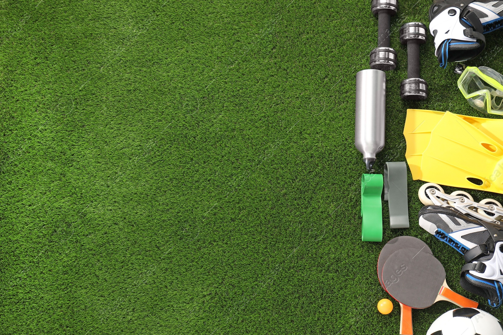 Photo of Different sport equipment on artificial grass, flat lay. Space for text