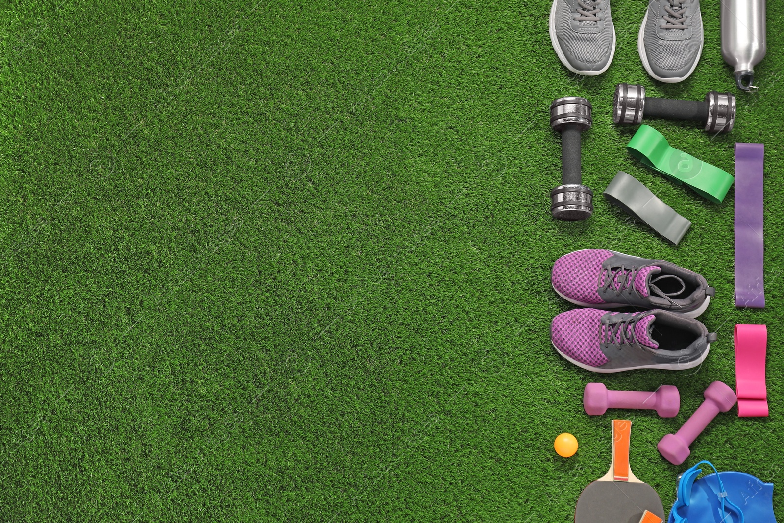 Photo of Different sport equipment on artificial grass, flat lay. Space for text