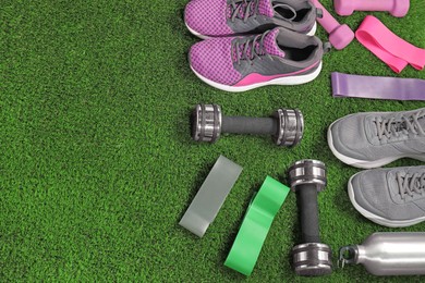 Photo of Different sport equipment on artificial grass, above view. Space for text