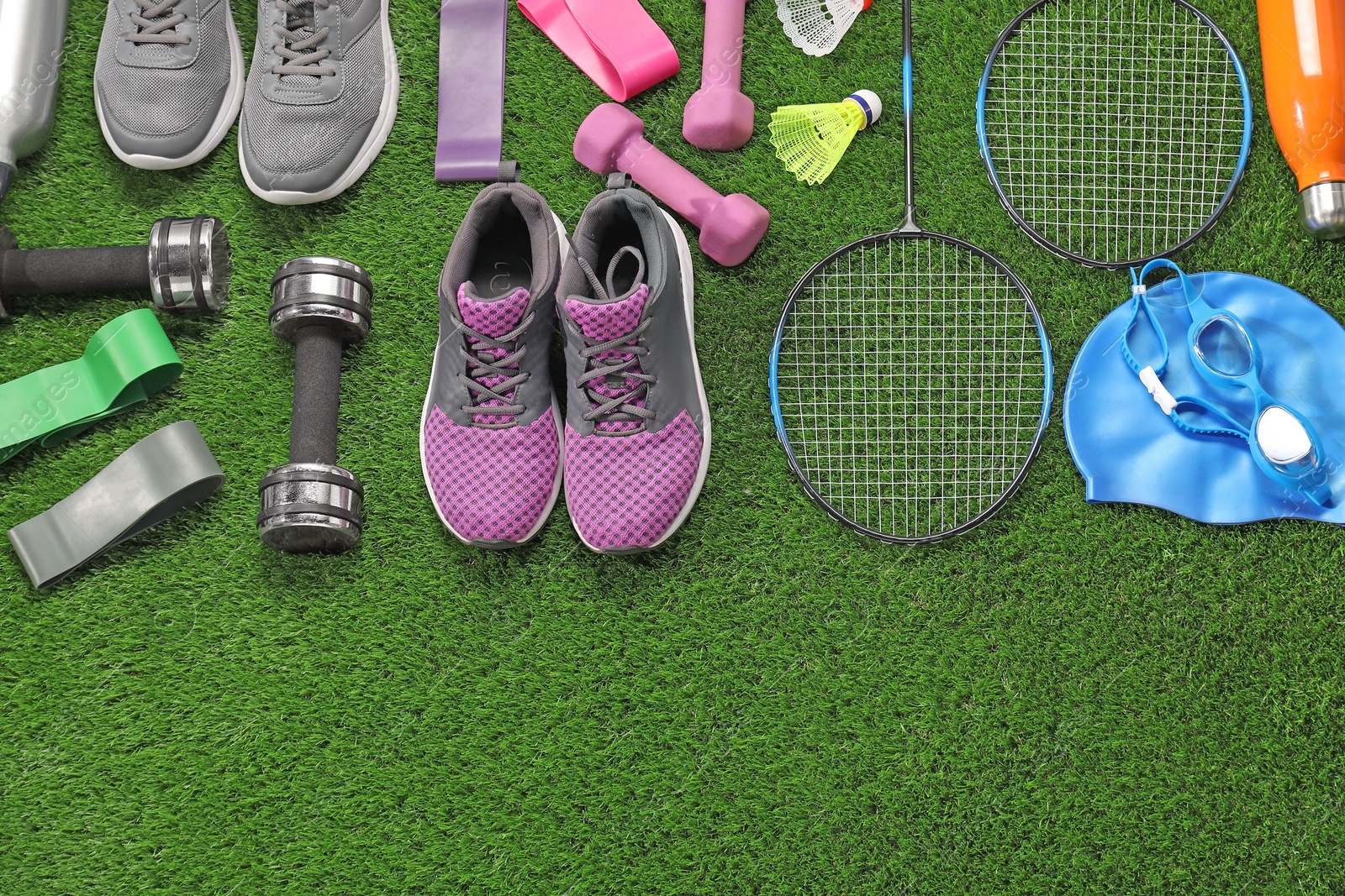 Photo of Different sport equipment on artificial grass, flat lay. Space for text