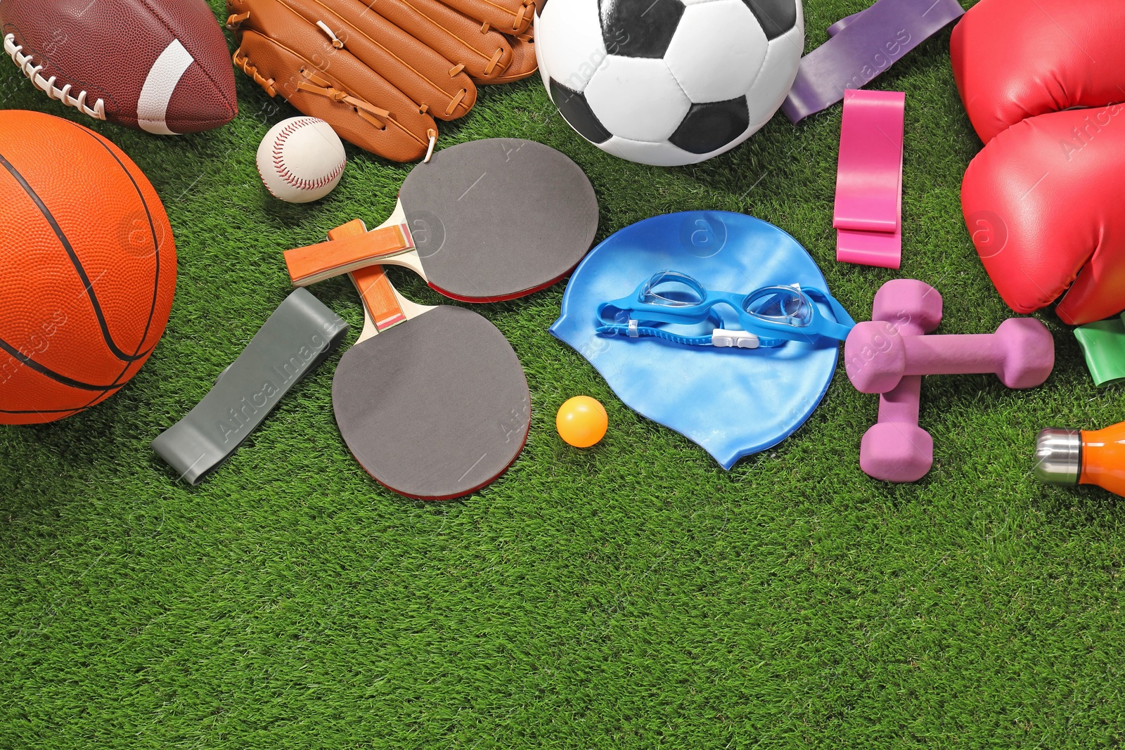 Photo of Different sport equipment on artificial grass, flat lay. Space for text