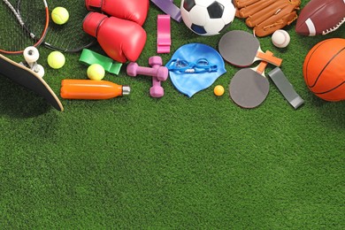 Different sport equipment on artificial grass, flat lay. Space for text