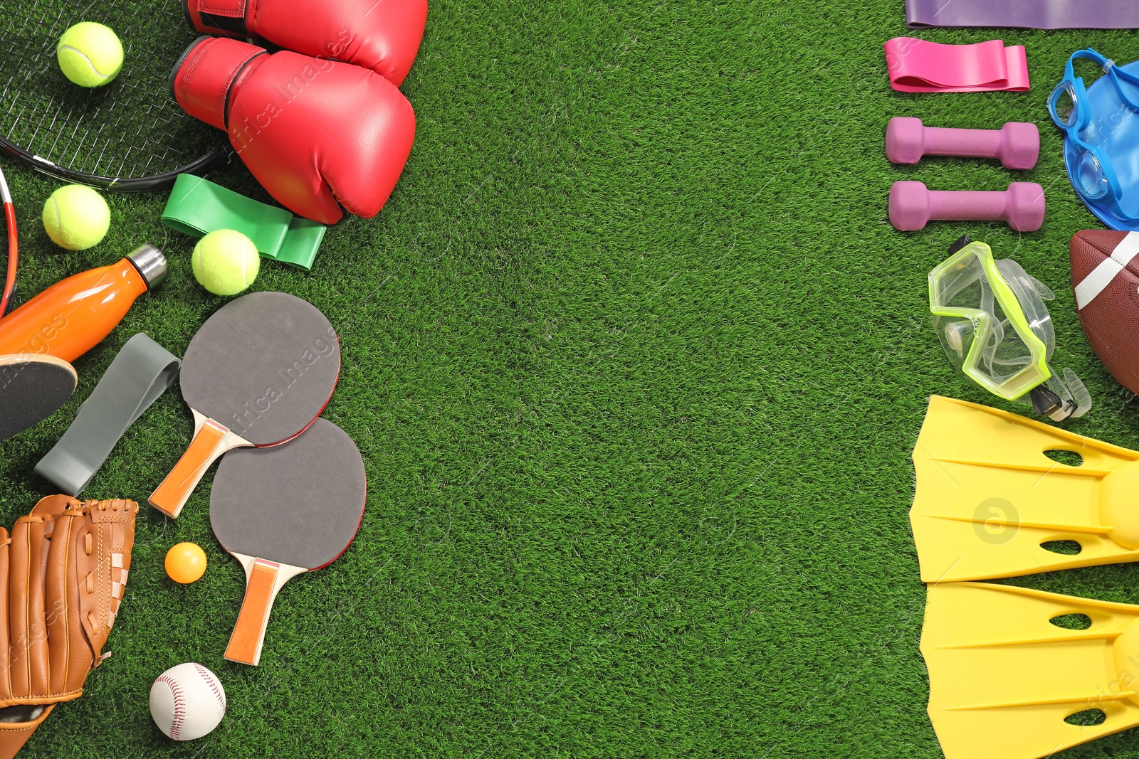 Photo of Different sport equipment on artificial grass, flat lay. Space for text