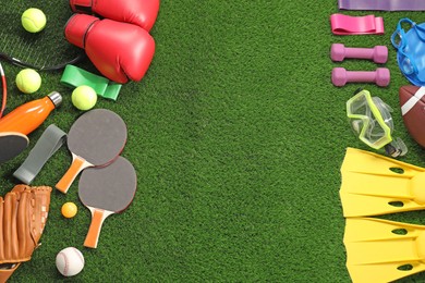 Photo of Different sport equipment on artificial grass, flat lay. Space for text