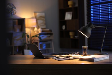 Photo of Workspace with laptop on wooden desk in home office. Space for text