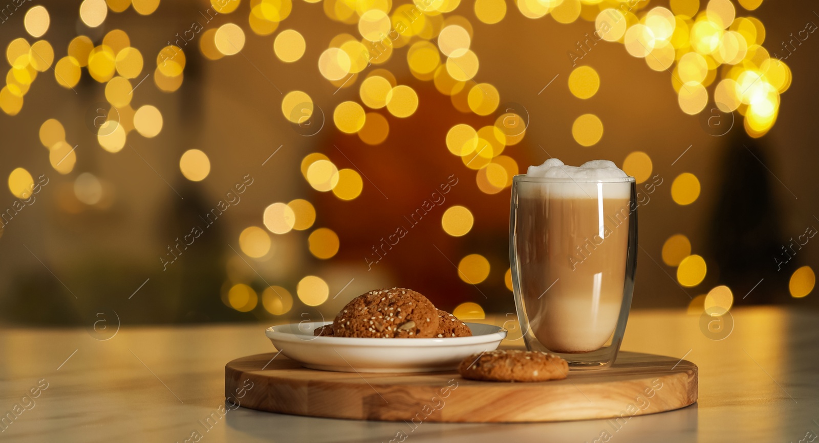 Photo of Aromatic coffee in glass and tasty cookies on table against blurred Christmas lights, bokeh effect. Space for text