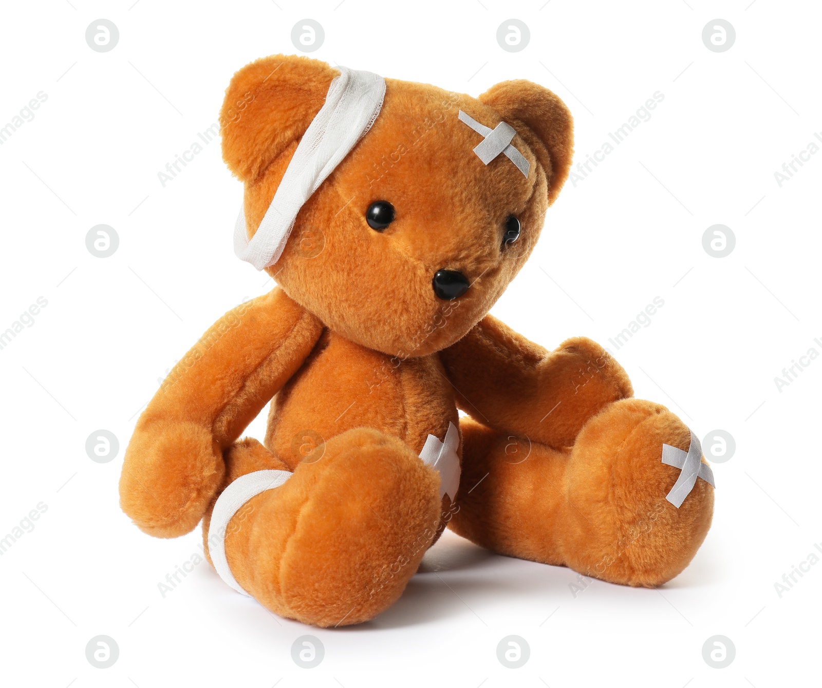 Photo of Teddy bear with bandages and adhesive medical plasters isolated on white