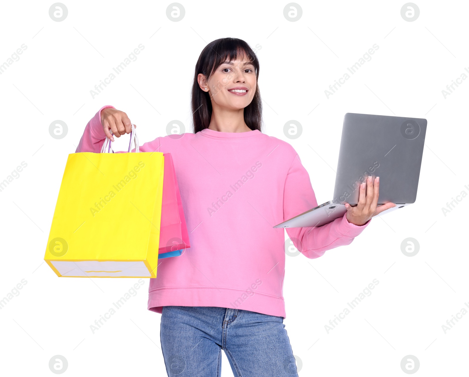 Photo of Internet shopping. Smiling woman with laptop and colorful bags on white background