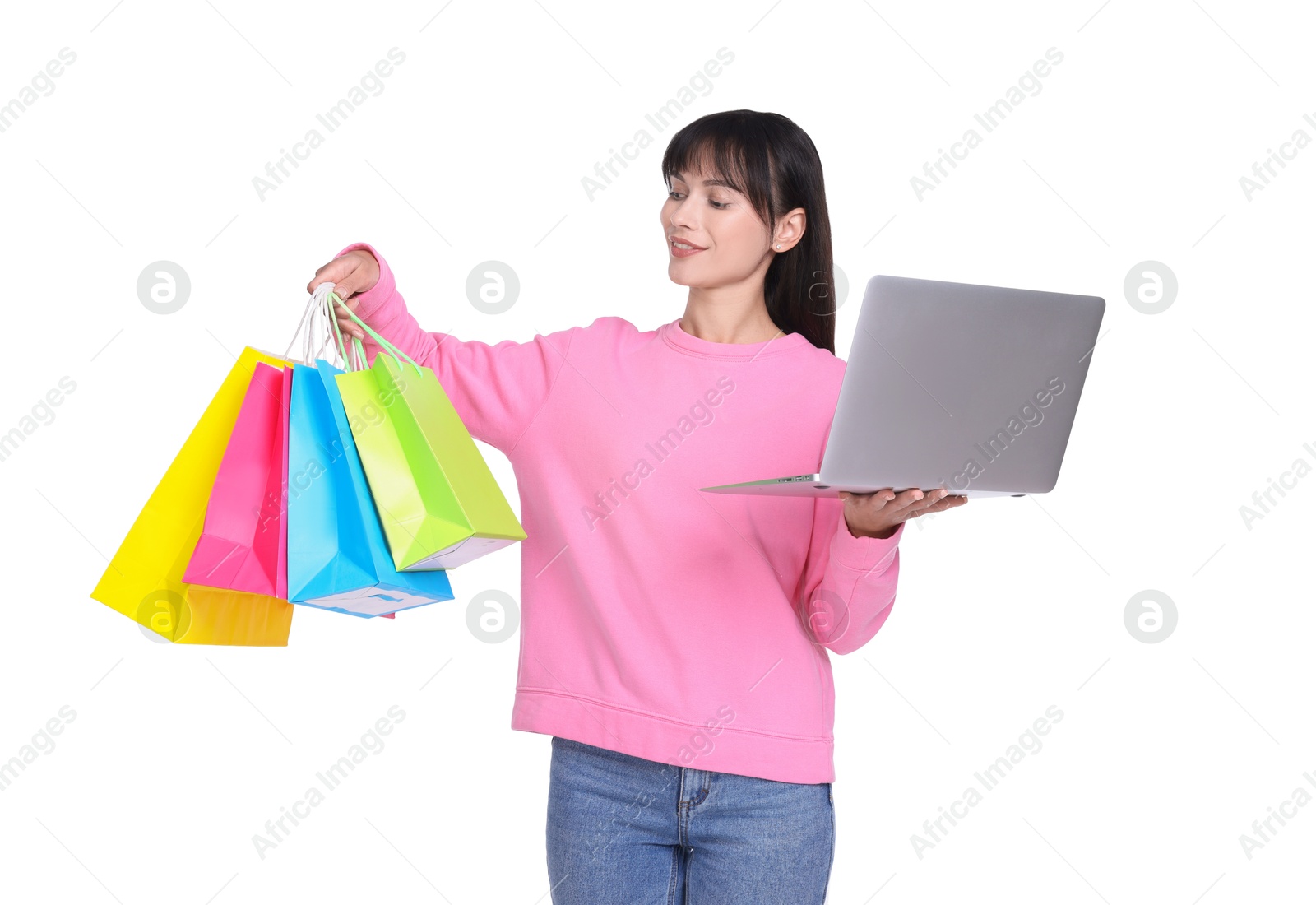 Photo of Internet shopping. Smiling woman with laptop and colorful bags on white background