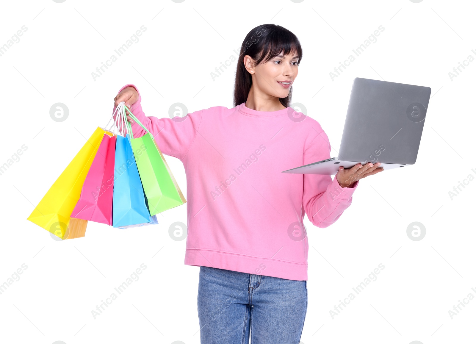 Photo of Internet shopping. Smiling woman with laptop and colorful bags on white background