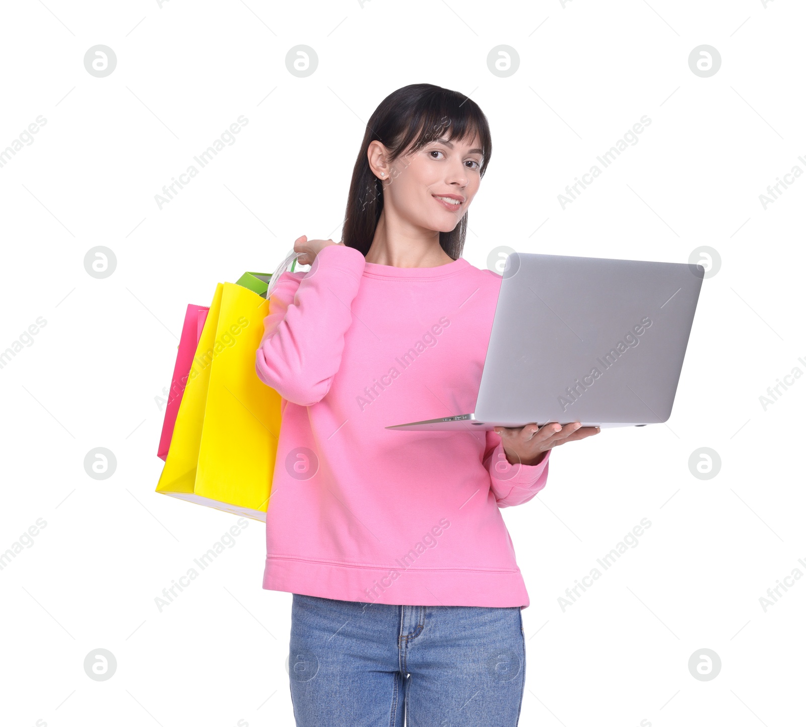 Photo of Internet shopping. Smiling woman with laptop and colorful bags on white background